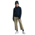 A person wearing a black Nike beanie, navy Nike "CFC" hoodie, tan cargo pants, and light blue sneakers, standing against a black background.