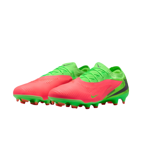 A pair of lime green and coral pink Nike soccer cleats with a textured upper and a studded green sole, set against a black background.