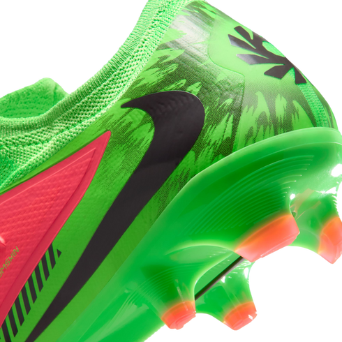 A close-up view of the heel and soleplate of a vibrant green Nike soccer cleat with a black swoosh, a neon pink accent panel, and orange-tipped studs against a black background.