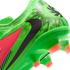 A close-up view of the heel and soleplate of a vibrant green Nike soccer cleat with a black swoosh, a neon pink accent panel, and orange-tipped studs against a black background.