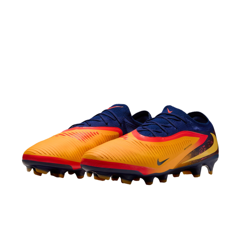 Nike soccer cleats with a navy blue and orange upper, red and yellow accents, and studded soles, shown against a black background.