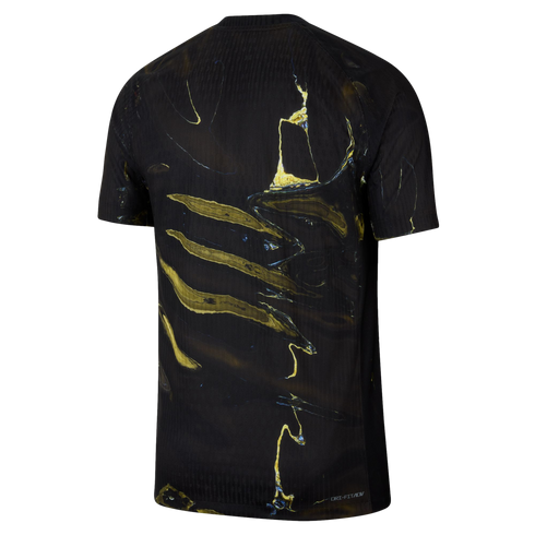 A back view of a black short-sleeved athletic shirt featuring a bold, abstract marbled pattern in shades of gold and yellow with subtle blue highlights.