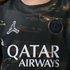 Close-up of a dark patterned Paris Saint-Germain jersey with silver Jumpman logo, black club crest, and white "QATAR AIRWAYS" text.