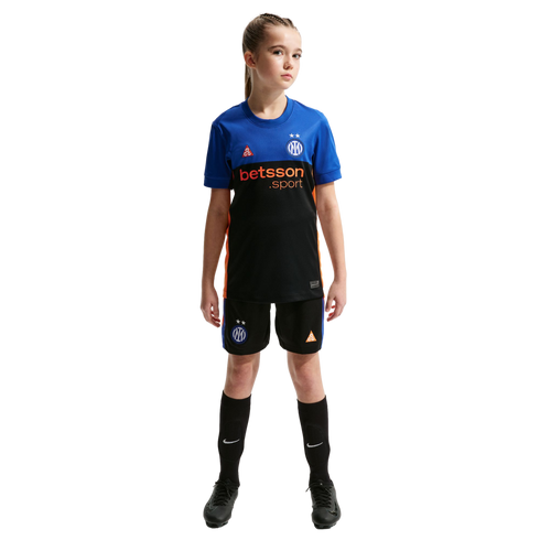 Young girl in a blue, black, and orange soccer kit featuring Inter Milan and betsson logos, standing against a black background.