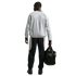 Rear view of a man in a grey 'Chelsea' jacket and navy track pants, holding a black duffel bag against a black background.