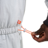 Close-up of a hand pulling an orange drawstring toggle on a light gray elastic waist garment with a small orange logo tag.