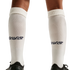 A close-up of a person's legs wearing white knee-high socks with a navy blue "USA" script logo on the calves and black athletic shoes, set against a solid black background.