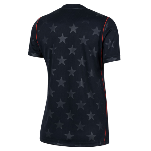 Back view of a black short-sleeved jersey with a subtle tonal star pattern and thin red vertical piping on the sides.