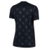 Back view of a black short-sleeved jersey with a subtle tonal star pattern and thin red vertical piping on the sides.