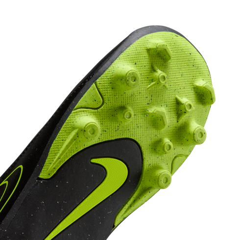 A close-up of the neon green and black sole of a Nike soccer cleat, showing molded studs and a green swoosh logo.