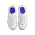 Top-down view of white Nike Gato indoor soccer shoes with blue insoles and pink accents, set against a black background.