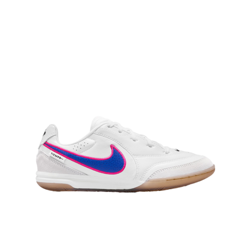White Nike Tiempo indoor soccer shoe with a blue and pink swoosh and gum rubber sole, shown from the side against a black background.
