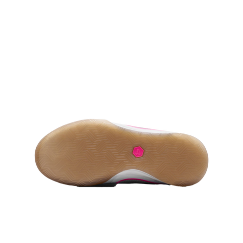 Bottom view of a Nike shoe featuring a gum rubber sole with a herringbone tread and a small pink hexagonal logo in the center.