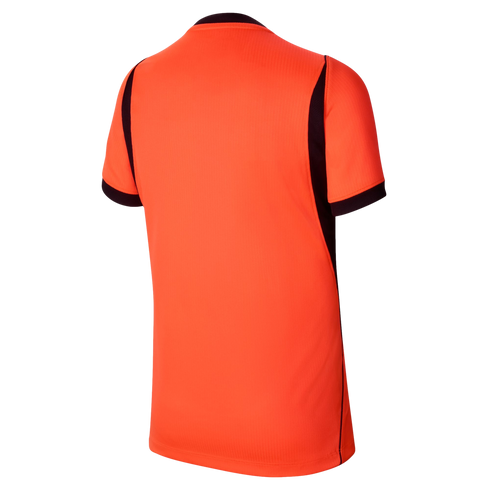 The back of a bright orange, short-sleeved athletic jersey shown against a black background. The jersey features black trim on the sleeve cuffs and black panels along the sides that taper up toward the shoulders. The fabric has a subtle vertical ribbed te