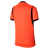 The back of a bright orange, short-sleeved athletic jersey shown against a black background. The jersey features black trim on the sleeve cuffs and black panels along the sides that taper up toward the shoulders. The fabric has a subtle vertical ribbed te