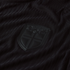 Close-up of a black textured jersey featuring a matte black shield crest with the word "NORGE" and a Nordic cross motif.