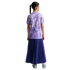 Back view of a girl with a braided ponytail wearing a purple floral t-shirt and a long navy pleated skirt against a black background.