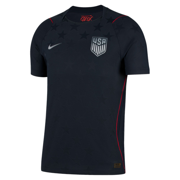 Dark navy Nike USA soccer jersey with silver team crest and swoosh. Features a tonal star pattern across the chest and thin red piping on the shoulders and sides.