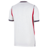 Rear view of a white short-sleeved sports jersey featuring red side panels and navy blue and red striped trim on the collar and sleeve cuffs, set against a solid black background.