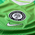 Close-up of a green Nigeria soccer jersey with a polka dot pattern, featuring the Nigeria Football Federation crest and a white Nike swoosh.