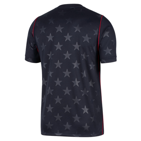 The back view of a black short-sleeved jersey featuring an allover tonal grey star pattern and thin red piping along the shoulder and side seams.