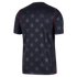 The back view of a black short-sleeved jersey featuring an allover tonal grey star pattern and thin red piping along the shoulder and side seams.