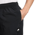 A close-up side view of a person wearing black Nike Air shorts with an elastic waistband, their hand tucked into a side pocket. A white Nike Air logo patch is visible on the thigh.