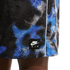 Close-up of Nike Air shorts with a blue and white pixelated graphic on black fabric and a branded patch.