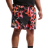 A person's mid-section wearing black Nike shorts featuring a vibrant, pixelated red, orange, and pink fire-like pattern with a small white logo.