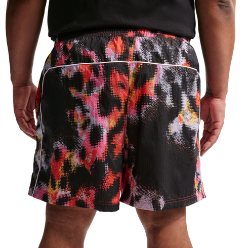 Back view of a person wearing a black shirt and shorts with a vibrant, pixelated abstract print in red, pink, orange, and white.