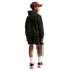 Back view of a child in a maroon cap, black hoodie, and shorts. They hold a silver water bottle and wear maroon sneakers against a black background.