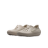 A pair of tan Nike foam clogs featuring perforated holes and wavy textured sides, displayed against a solid black background.