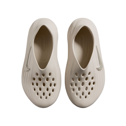 Top-down view of a pair of beige Nike foam clogs with perforated toes and textured sides, set against a black background.