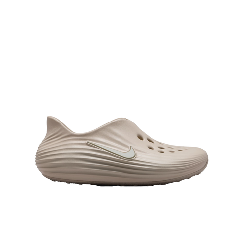 Profile view of a light beige Nike foam clog with a white swoosh and top perforations, isolated on a black background.