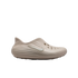 Profile view of a light beige Nike foam clog with a white swoosh and top perforations, isolated on a black background.