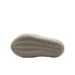 The light beige underside of a Nike shoe featuring a textured traction pattern of concentric circles and small lugs on a solid black background.