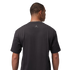 Rear view of a man wearing a charcoal gray Jordan t-shirt with a small silver Jumpman logo on the upper back. He is set against a solid black background.