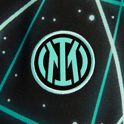 Close-up of the mint green and black Inter Milan club crest embroidered on a geometric patterned fabric.
