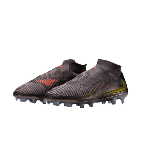 A pair of charcoal grey Nike laceless soccer cleats with a high-top knitted collar, featuring orange and lime green accents against a solid black background.