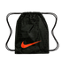 A black Nike drawstring bag with a large bright orange swoosh on the front. The bag features a subtle, repeating pattern of the word "Nike" alongside words for "soccer" in various languages. Two black drawstrings at the top serve as a cinch closure and sh