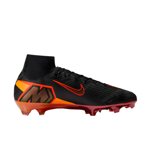 A side view of a Nike Mercurial Superfly soccer cleat featuring a black knit upper and a high-top collar. An orange Nike Swoosh with a red outline is on the side, and a large bronze "M" logo is set into an orange and red graphic on the heel. The soleplate