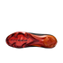 A bottom view of a Nike soccer cleat sole featuring a glossy metallic red and orange gradient against a black background. The forefoot displays chevron-shaped studs and the words "AIR ZOOM" in black.