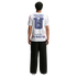 Rear view of a person wearing a white t-shirt with "United States of America" and a large blue logo on the back, paired with black wide-leg trousers.