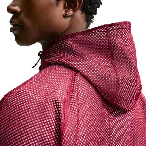A profile view of a person wearing a burgundy mesh hoodie against a solid black background.