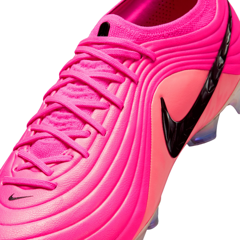 A vibrant pink Nike soccer cleat with a textured, ribbed upper, matching pink laces, and a prominent black swoosh logo on a plain white background.