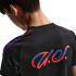 Close-up rear view of a person in a black jersey featuring a stylized red and blue gradient logo and shoulder stripes.