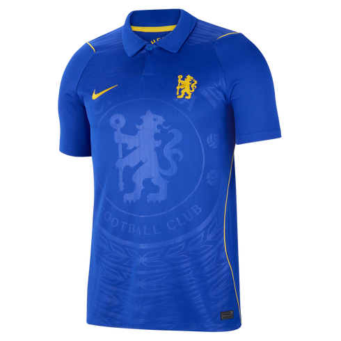 A blue Nike Chelsea FC short-sleeve polo jersey featuring a yellow club crest, yellow Nike swoosh, and a large tonal embossed Chelsea crest in the center.