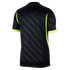 The back view of a black short-sleeved jersey featuring a geometric triangle pattern and neon yellow accents on the sides and sleeve cuffs.