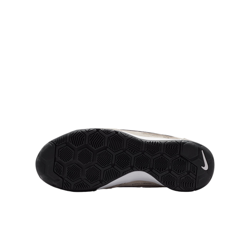 The bottom view of a Nike shoe's black rubber sole with a hexagonal tread pattern and white swoosh logo, shown against a solid black background.