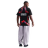 Rear view of a man wearing a black t-shirt with a large red star graphic and "STATES" text, paired with baggy light-colored pants against a black background.